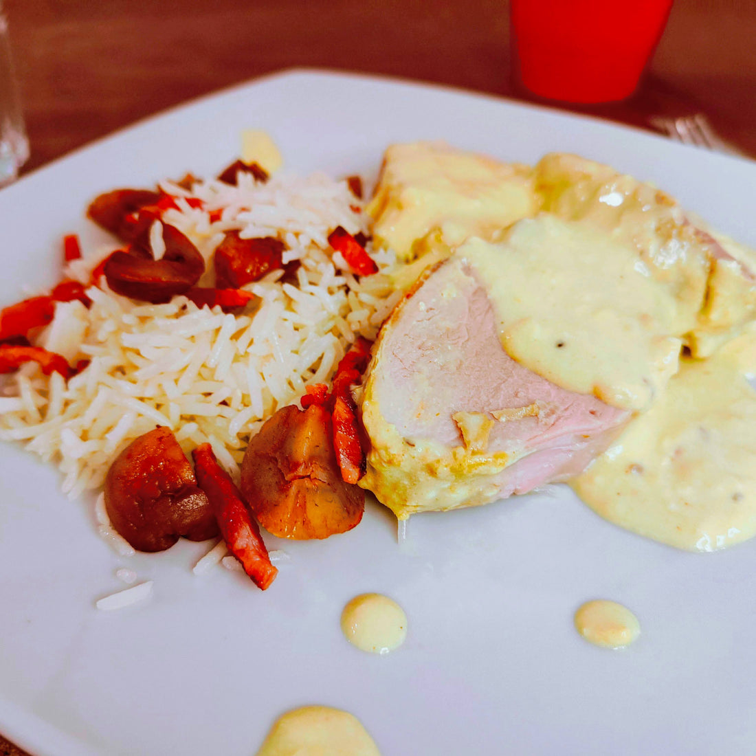 Prato servido à mesa, com arroz, chouriço e molho